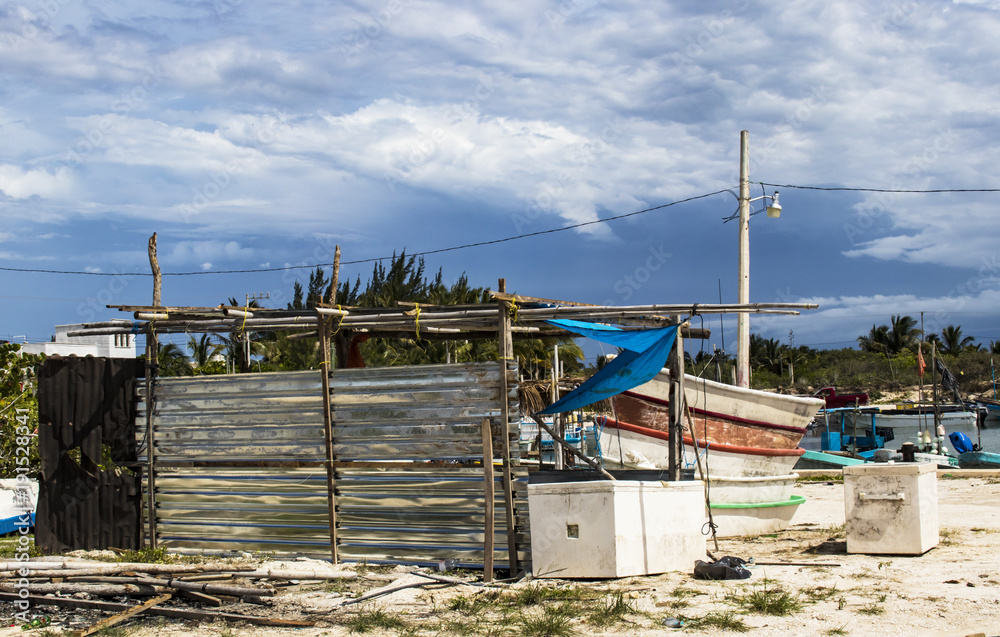 Scene from Mexican fishing marina in the Yucatan during the rainy season - boats and equipment all around
