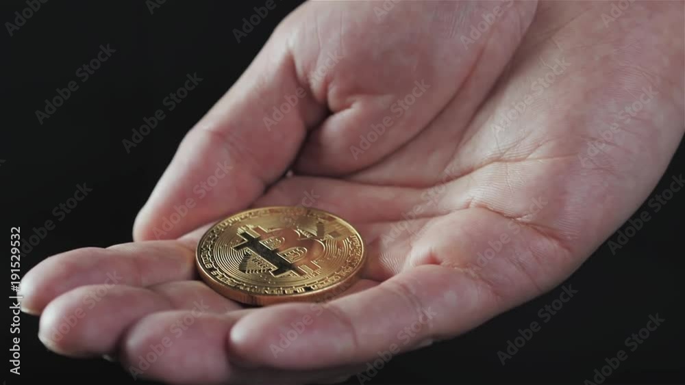 Gold bitcoin coin stacked against a dark background close-up. Bitcoin cryptocurrency in hand ethereum ico blockchain