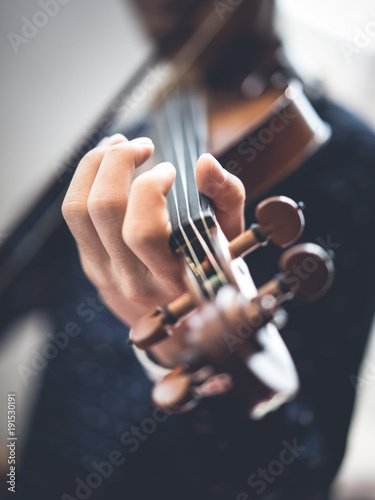 A young man is playing a violin.