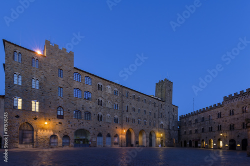 Pretorio Palace and Porcellino Tower, Priori square in a quiet moment of the evening in the blue light, Volterra, Pisa, Tuscany, Italy