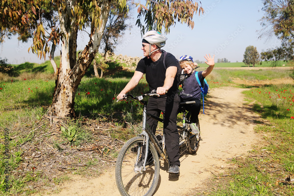 father with autistic 10 years old son ride a tandem bike Stock Photo
