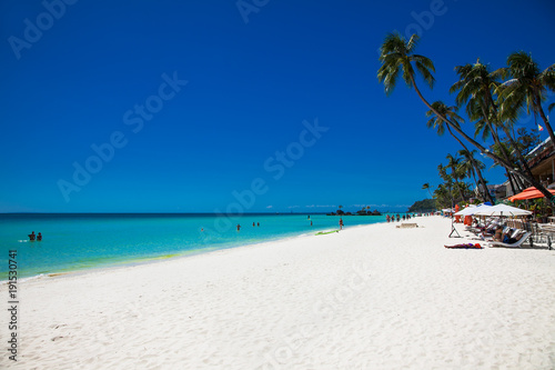 Tropical vacation , sun, blue sky and palm tree on White beach at Boracay, Philippines.