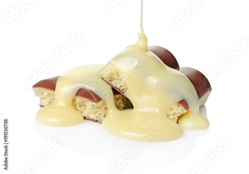 Fotografie Close-up pieces of porous chocolate bar poured liquid white chocolate