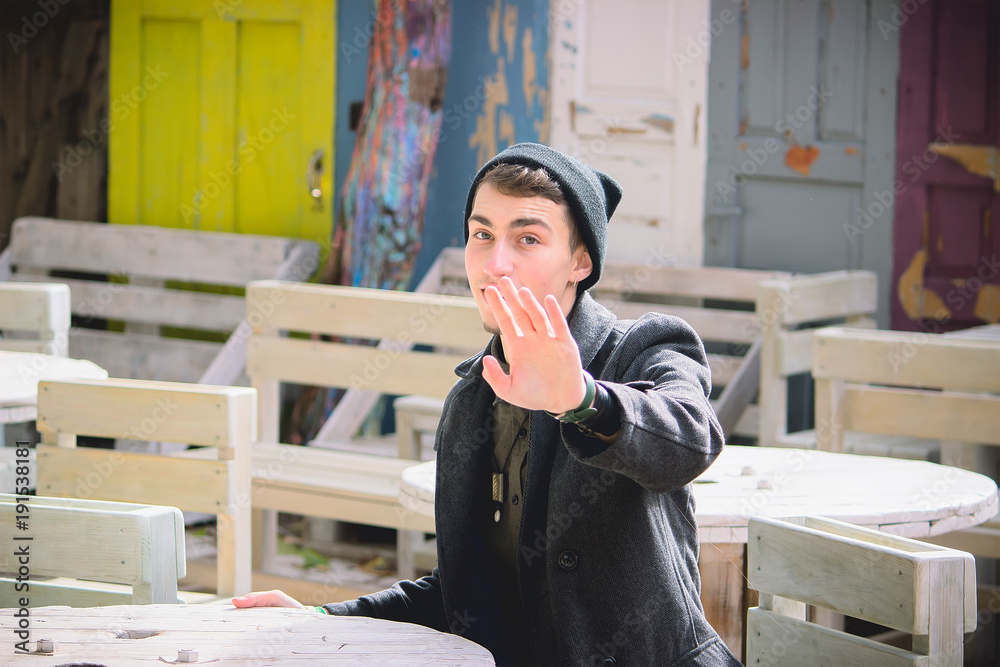 Fototapeta premium the boy in the street gently waving his hand and smile