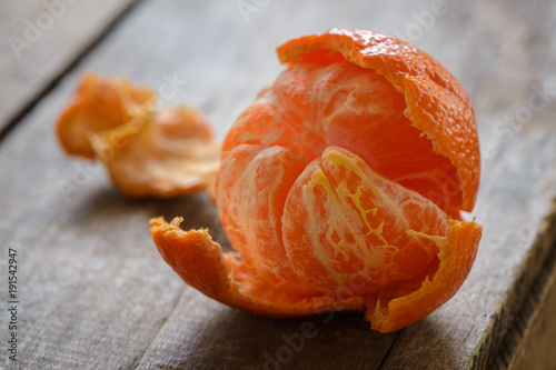 Partially peeled mandarin orange on a wood surface