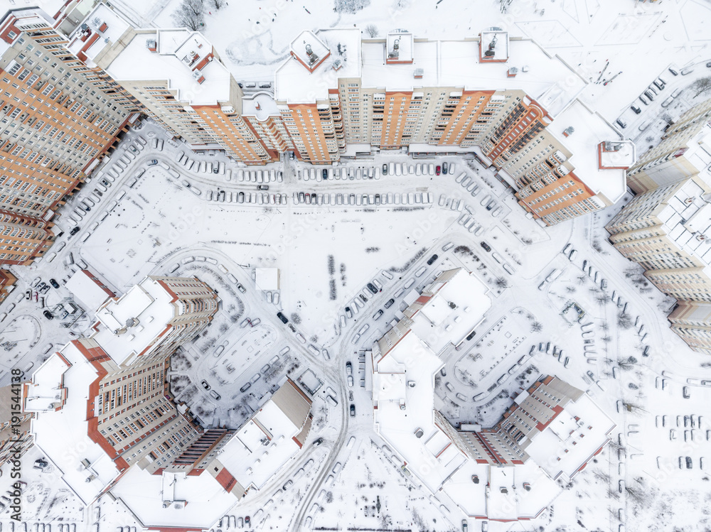 Fototapeta premium Top view at the dwelling district with snow covered inner yards and lot of parked cars. Winter season. St. Petersburg, Russia.