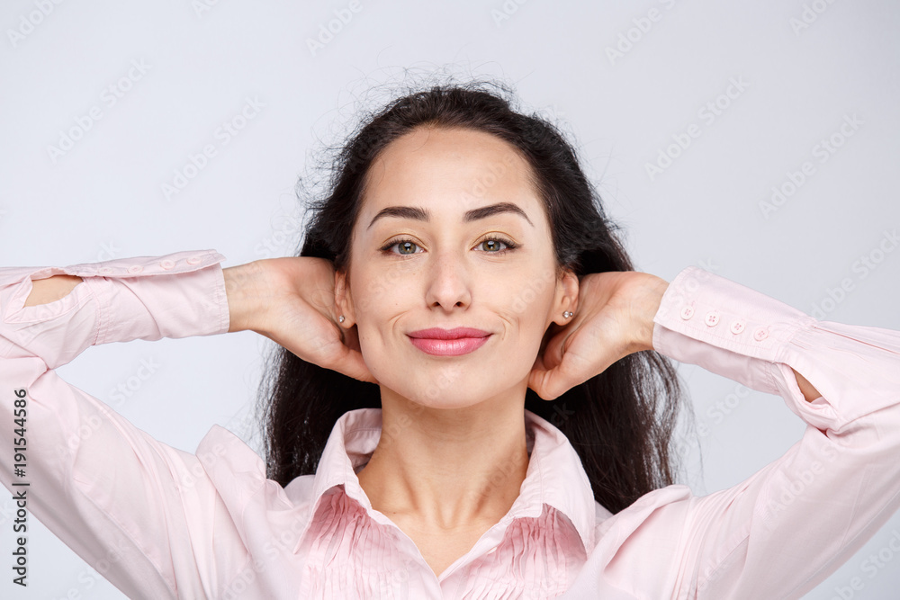 Portrait of a beautiful brunette girl with dark skin in a pink shirt, with a serious expression. Emotion view is arrogant with high. Businesswoman porter without a smile on a white background Portrait of a beautiful brunette girl with dark skin in a pink shirt, with a serious expression. Emotion view is arrogant with high. Businesswoman porter without a smile on a white background