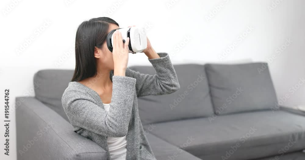 Woman playing with virtual reality device at home Woman playing with virtual reality device at home