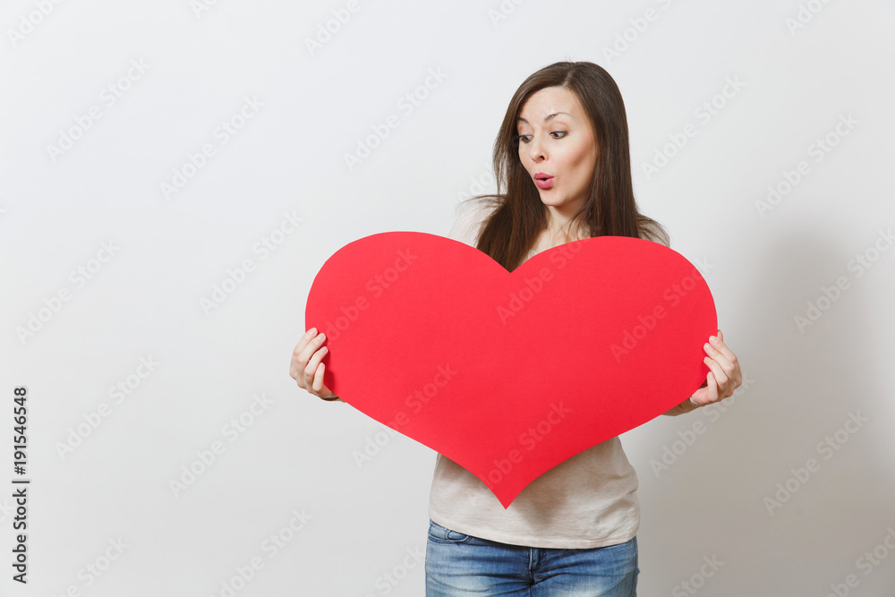 Beautiful young smiling woman holding big red heart in hands isolated on white background. Copy space for advertisement. With place for text. St. Valentine's Day or International Women's Day concept. Beautiful young smiling woman holding big red heart in hands isolated on white background. Copy space for advertisement. With place for text. St. Valentine's Day or International Women's Day concept.