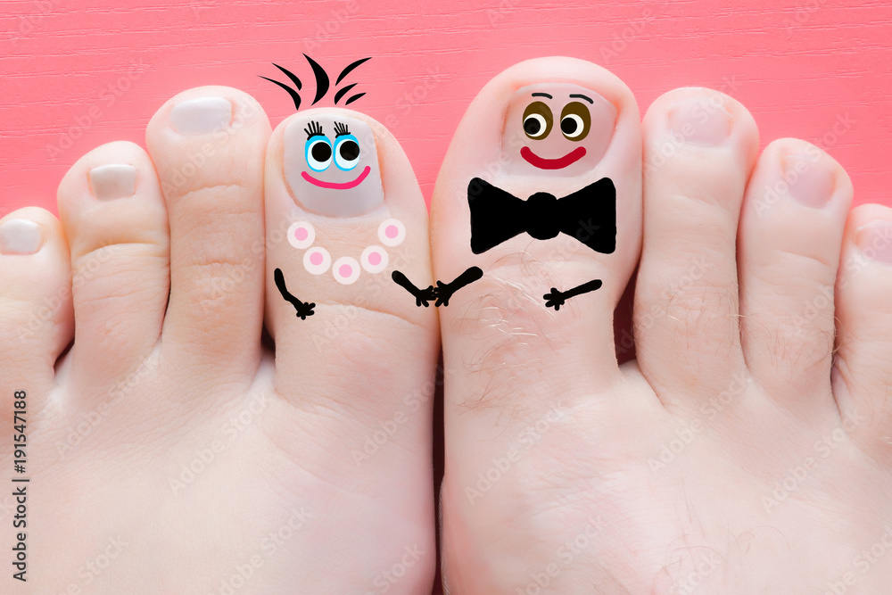 Young couple's feet together with funny drawn happy, smiling faces