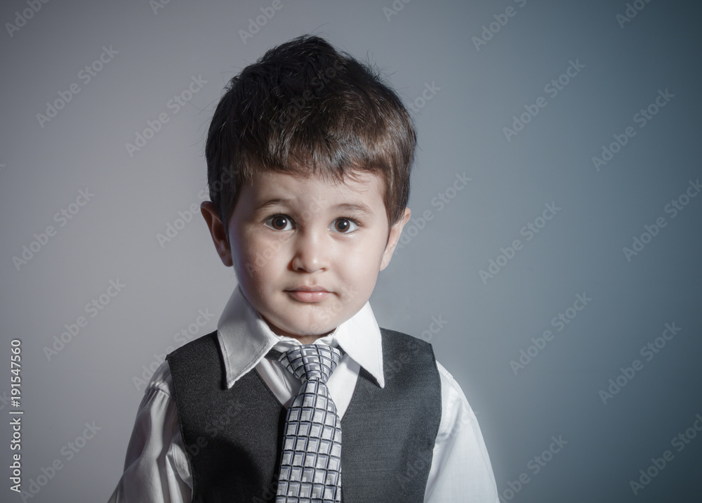 little businessman, brown-haired boy dressed in suit and tie with faces and funny expressions little businessman, brown-haired boy dressed in suit and tie with faces and funny expressions