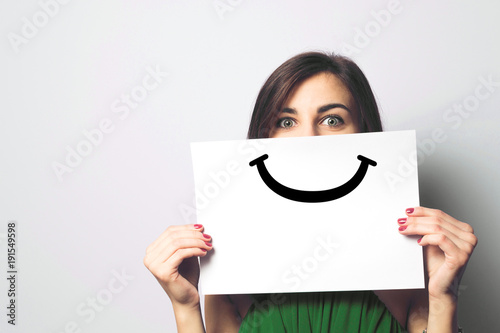 Fotografia Happy and smiling girl with a smile painted on paper