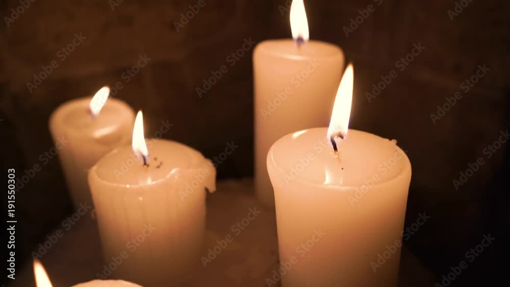 Five flickering candles on the black background. Five flickering candles on the black background.