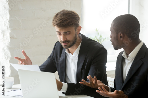 Multi-ethnic colleagues having claims fight about mistake in business document, diverse executive team disagree with bad contract terms, partners arguing about paperwork, disputing over agreement photo