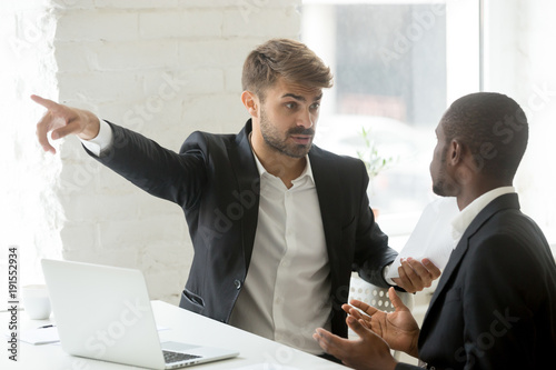Quadro em tela Angry rude caucasian executive firing male incompetent african employee for bad