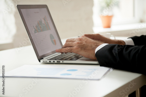 Businessman works with project statistics analyzing financial graphs charts on laptop screen, marketing manager using business software for online data analysis strategic planning concept, close up