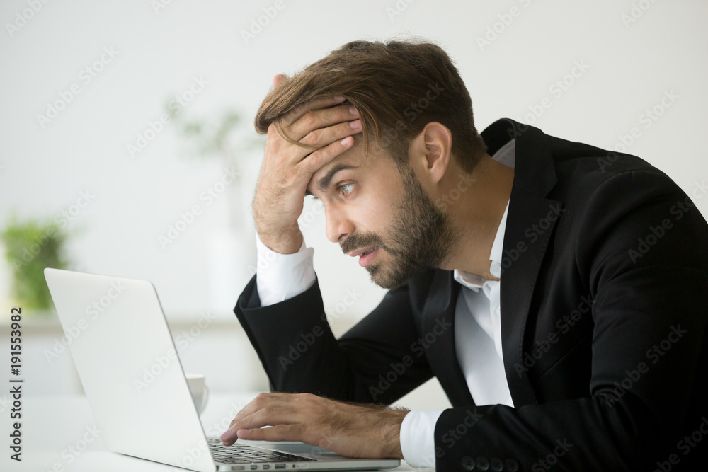 Worried stressed businessman in suit shocked by bad news using laptop at work, desperate bankrupt investor lost money online depressed by financial problem debt, frustrated worker tired of overwork Worried stressed businessman in suit shocked by bad news using laptop at work, desperate bankrupt investor lost money online depressed by financial problem debt, frustrated worker tired of overwork