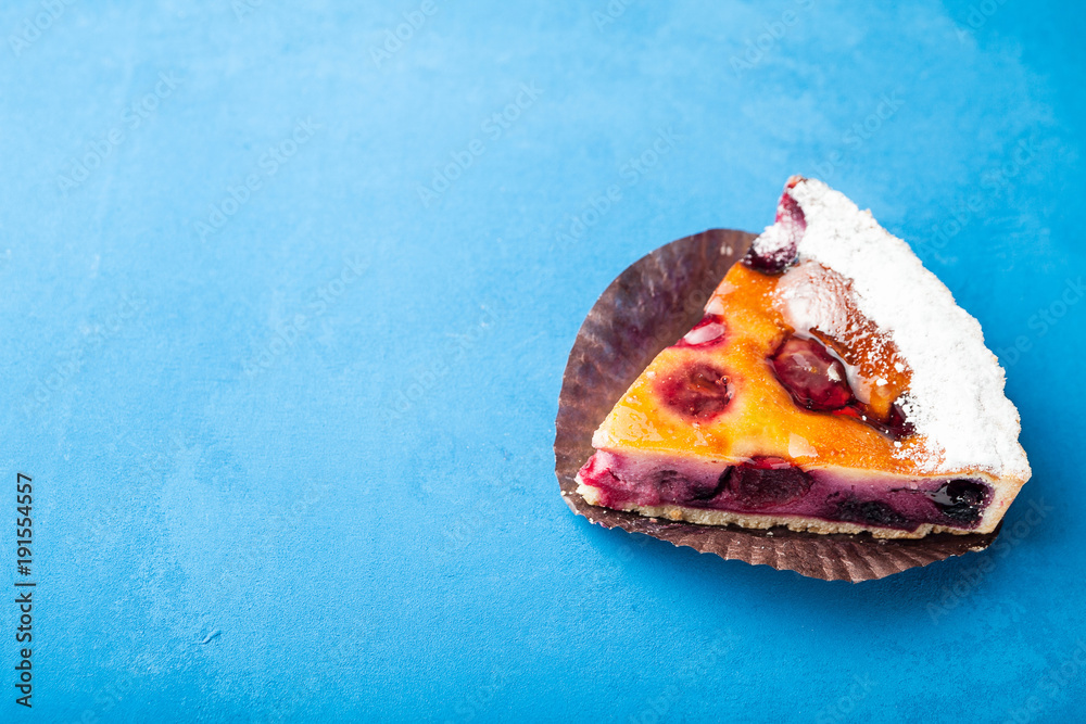 A slice of cherry homemade pie on a blue background. Copy space. A slice of cherry homemade pie on a blue background. Copy space.