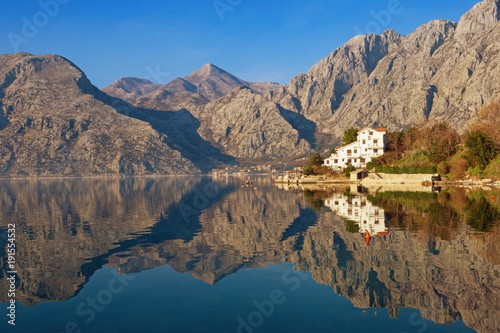 Mountains reflected in the water of Bay of Kotor on calm winter day. Montenegro, Dobrota