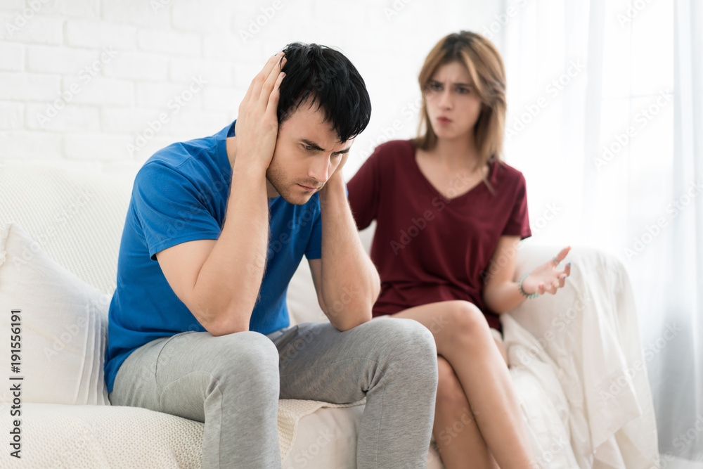 Couple having argument conflict, bad relationships. Angry fury woman screaming man close his ears in house.