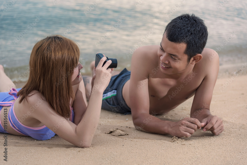 Woman taking photo picture of man smiling happy with camera Woman taking photo picture of man smiling happy with camera