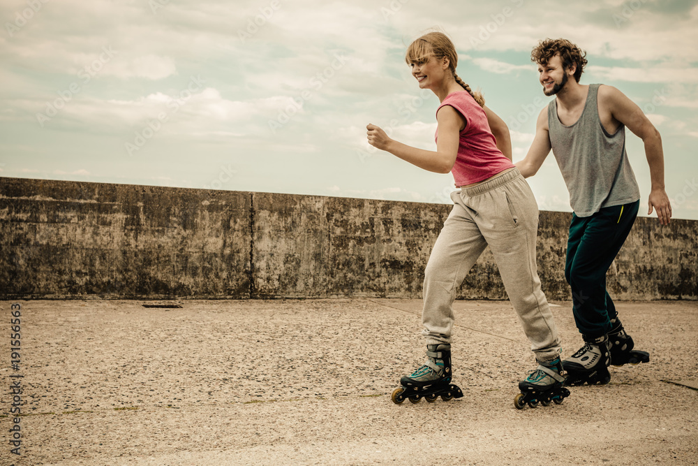Two people race together riding rollerblades. Two people race together riding rollerblades.