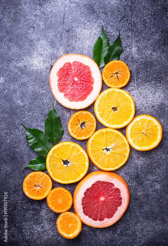 Different sliced citrus on dark concrete background © Yulia Furman