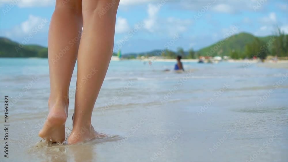 Close up female feet walking barefoot on the beach. Slow Motion. Close up female feet walking barefoot on the beach. Slow Motion.