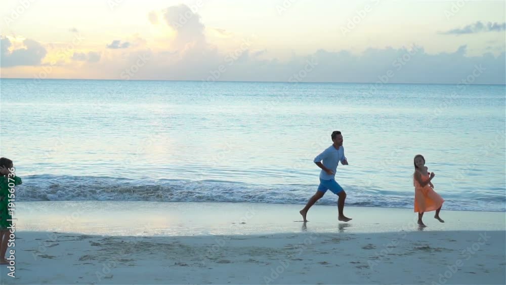 Family having fun on the beach at sunset. SLOW MOTION