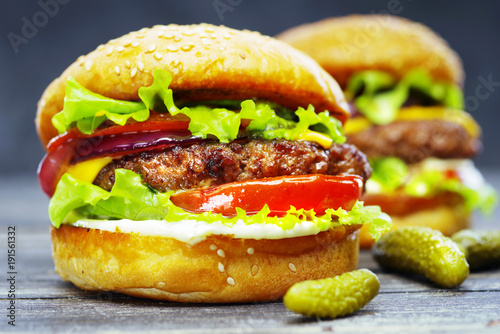 Close-up of delicious burgers on a wooden table.