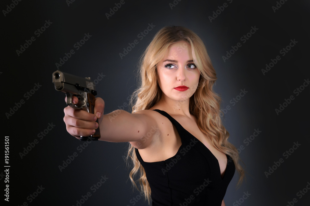 Jeune belle femme tenant un pistolet Jeune belle femme tenant un pistolet