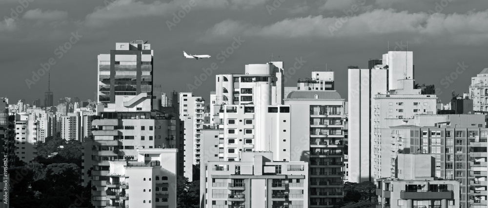 Urban landscape with plane in the sky