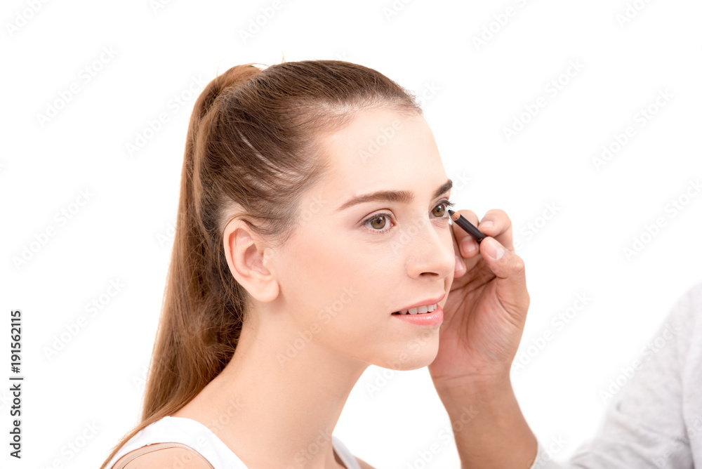 Closed up of face Young caucasian beautiful girl with hand applying make-up by make-up artist,isolated on white ,copy space Closed up of face Young caucasian beautiful girl with hand applying make-up by make-up artist,isolated on white ,copy space