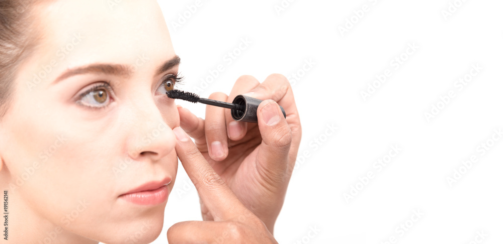 .Closed up of face Young caucasian beautiful girl with hand applying make-up by make-up artist,isolated on white ,copy space .Closed up of face Young caucasian beautiful girl with hand applying make-up by make-up artist,isolated on white ,copy space