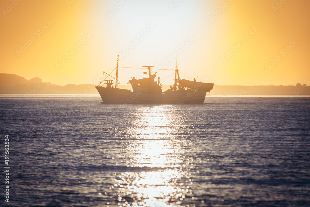 Fishing cutter against sunset sky on Douro River in Porto, Portugal