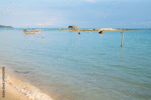 Asian idyllic coastal scene with traditional long tail fishing boats.