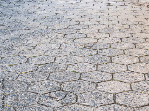 Fotografie Street perspective texture of hexagonal concrete blocks, poorly maintained and d