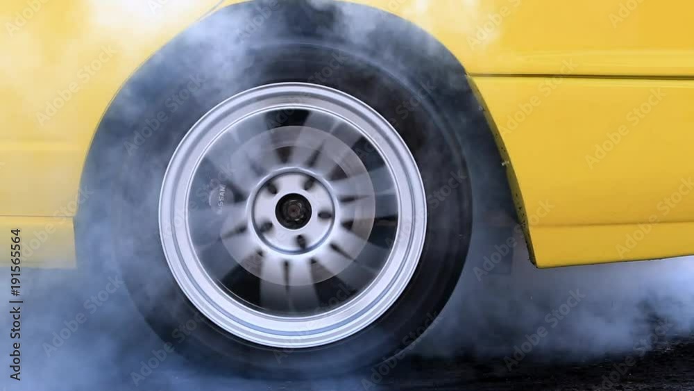 Drag racing car burns rubber off its tires in preparation for the race ...