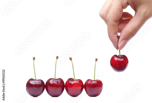 Female hand picking up a red cherry isolated on white 