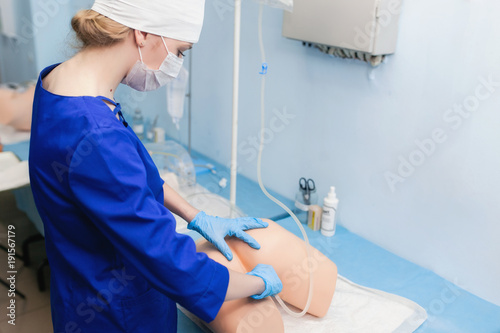 cleaning rectum on a medical mannequin. Training of a medical student in process of climatization photo