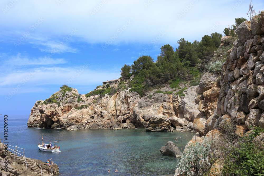 Europe, Spain, Balearic Islands, Mallorca. Cala Banyalbufar. Beachfront swimming. Harbor, Sunbathers. Boats.