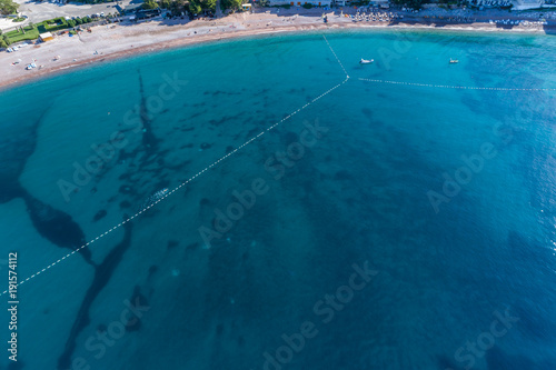 Aerial view of the turquoise sea surface in which people bathe 