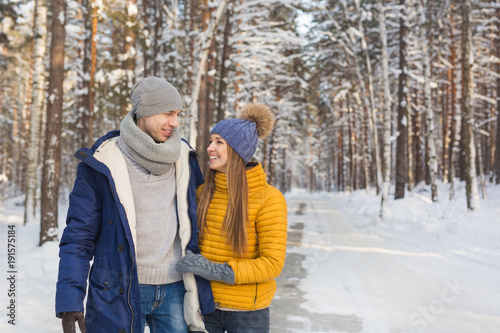 Smiling young couple looking face to face in a forest in the winter