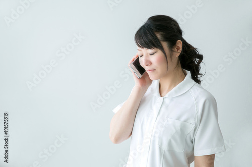 電話する白衣の女性 
