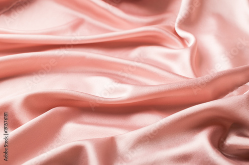 Background of satin pink cloth draped in waves. Copy space. A place for design.