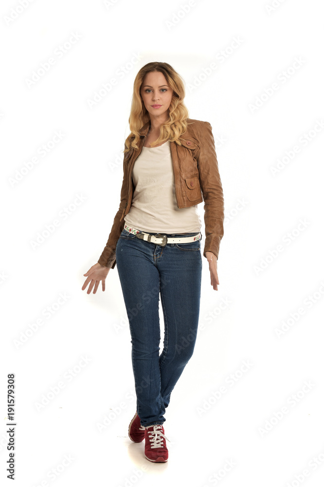 full length portrait of blonde girl wearing simple brown jacket and jeans, standing pose on white studio background. full length portrait of blonde girl wearing simple brown jacket and jeans, standing pose on white studio background.
