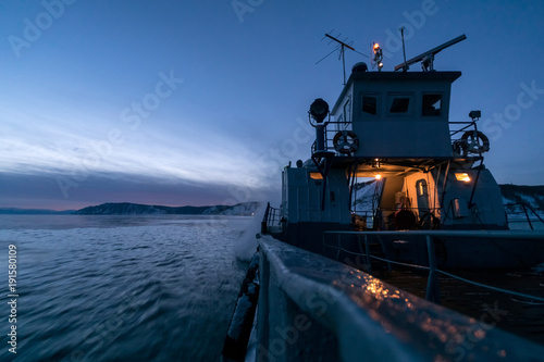 The ferry sails along Lake Baikal on a winter evening