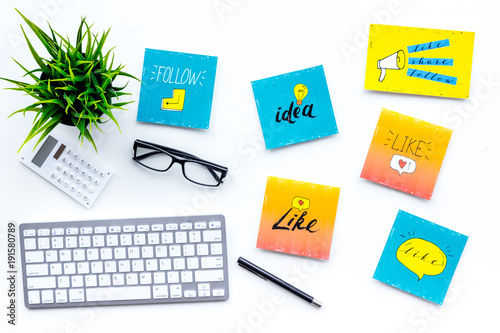 Digital marketing. Work desk of marketing specialist with social media icons and symbols on white background top view