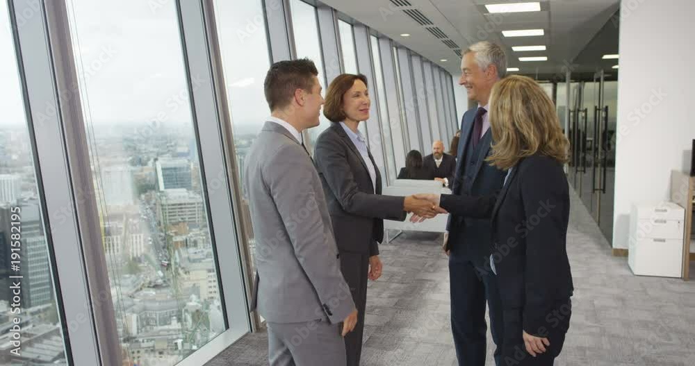 4K Smiling corporate business group greet each other & shake hands in city office 4K Smiling corporate business group greet each other & shake hands in city office