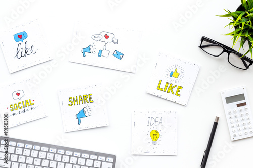 Digital marketing. Work desk of marketing specialist with social media icons and symbols on white background top view copy space